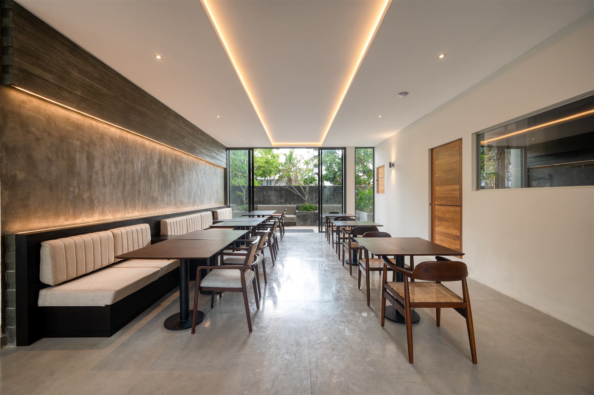 Indoor dining room with banquette seating and warm cove lighting
